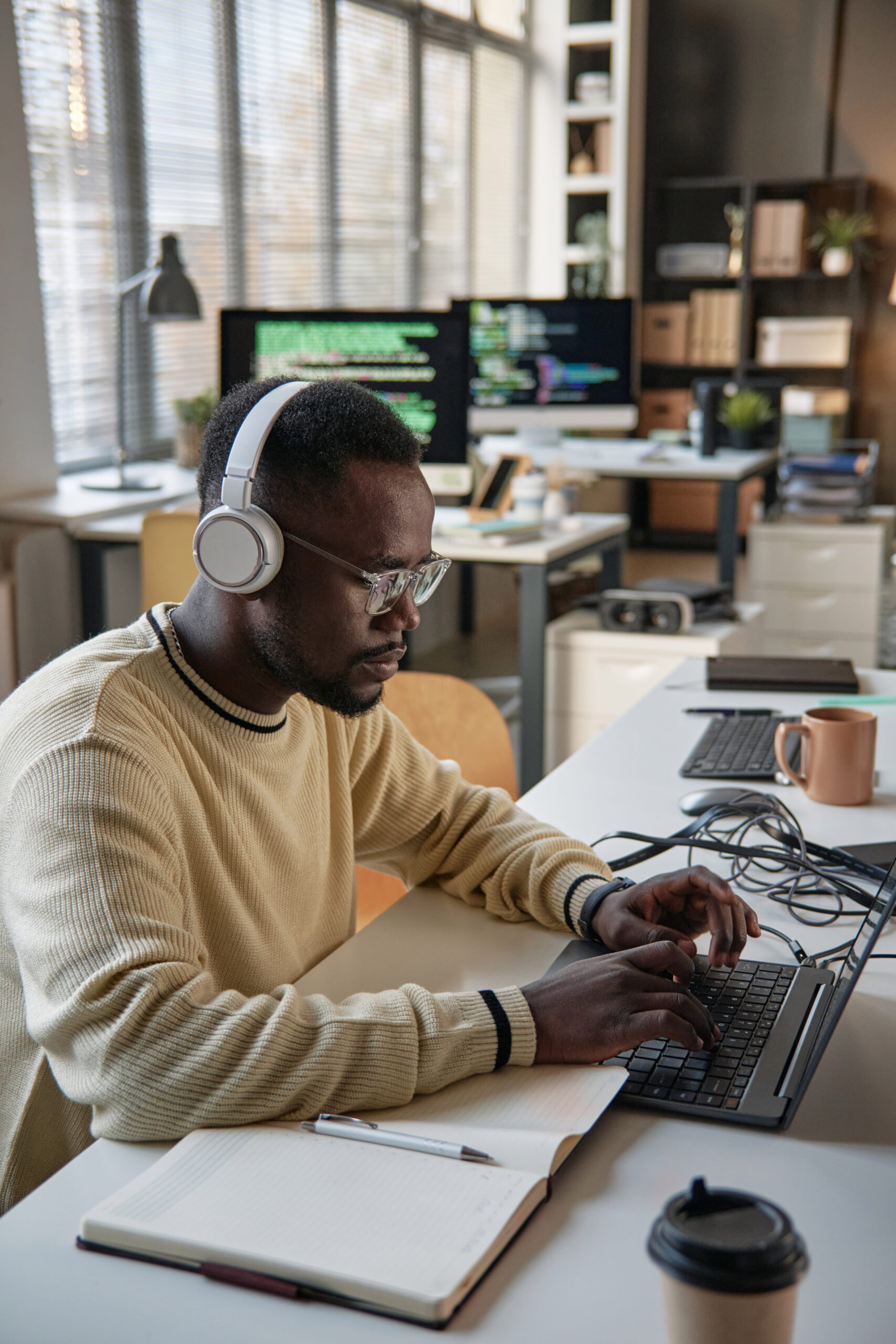 Young Black software developer working on laptop in office of startup company